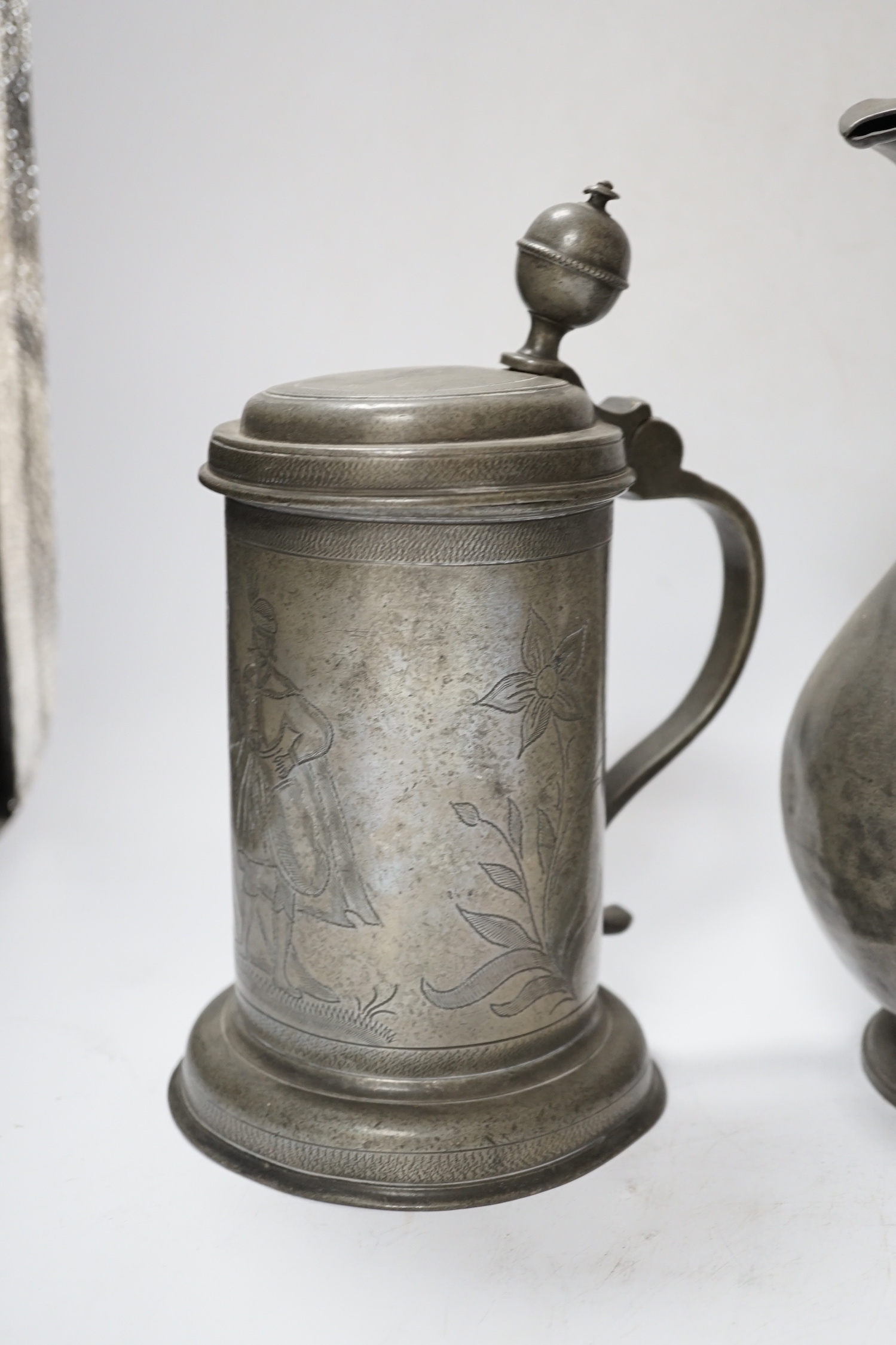 Six pewter items including an 18th-century Continental wriggle work tankard, two more tankards and two lidded jugs and a lead mounted figure of a Medieval king, lead figure 35cm high